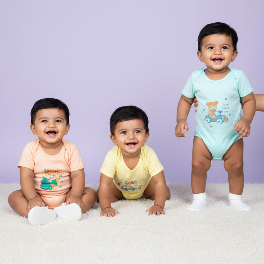 Peach, yellow and aqua cotton baby bodysuits in a pack of three.